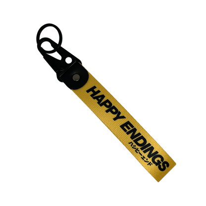 Yellow key tag with Happy Endings branding and Japanese text – Motorev car accessory