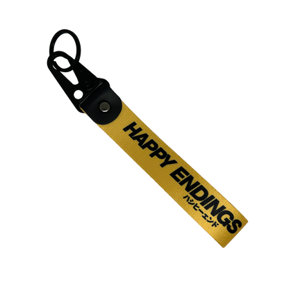 Yellow key tag with Happy Endings branding and Japanese text – Motorev car accessory