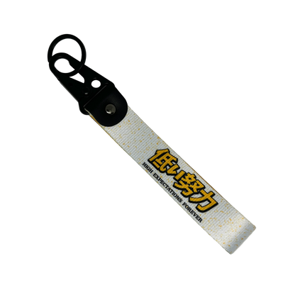 Motorev High Expectations Forever car key tag, a zinc alloy and nylon JDM keyring featuring a bold motivational design, scratch resistant and built for JDM and car culture enthusiasts UK