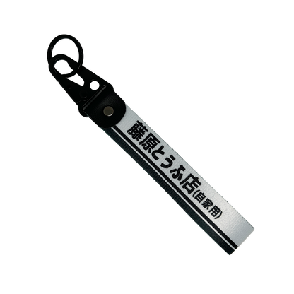 White keychain with a black line accent feauring Japanese text reading "Fujiwara Tofu Shop" – Motorev JDM car accessory