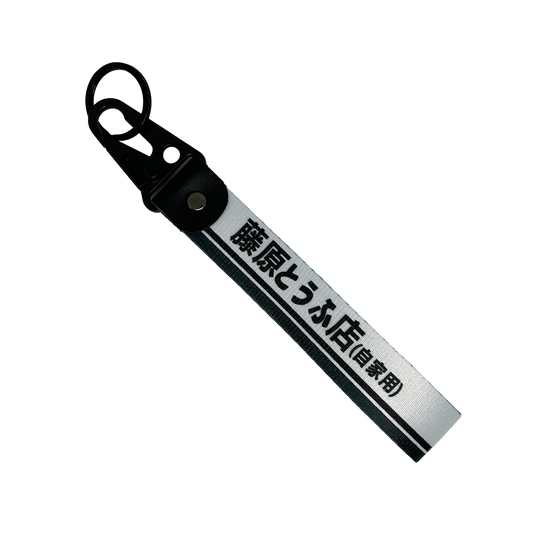 White keychain with a black line accent feauring Japanese text reading "Fujiwara Tofu Shop" – Motorev JDM car accessory