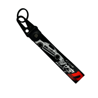 Motorev Initial D AE86 Trueno car key tag, a black wrist strap JDM keyring featuring the iconic Toyota AE86 Trueno silhouette with Japanese kanji and Initial D branding, built for JDM and anime car culture enthusiasts UK